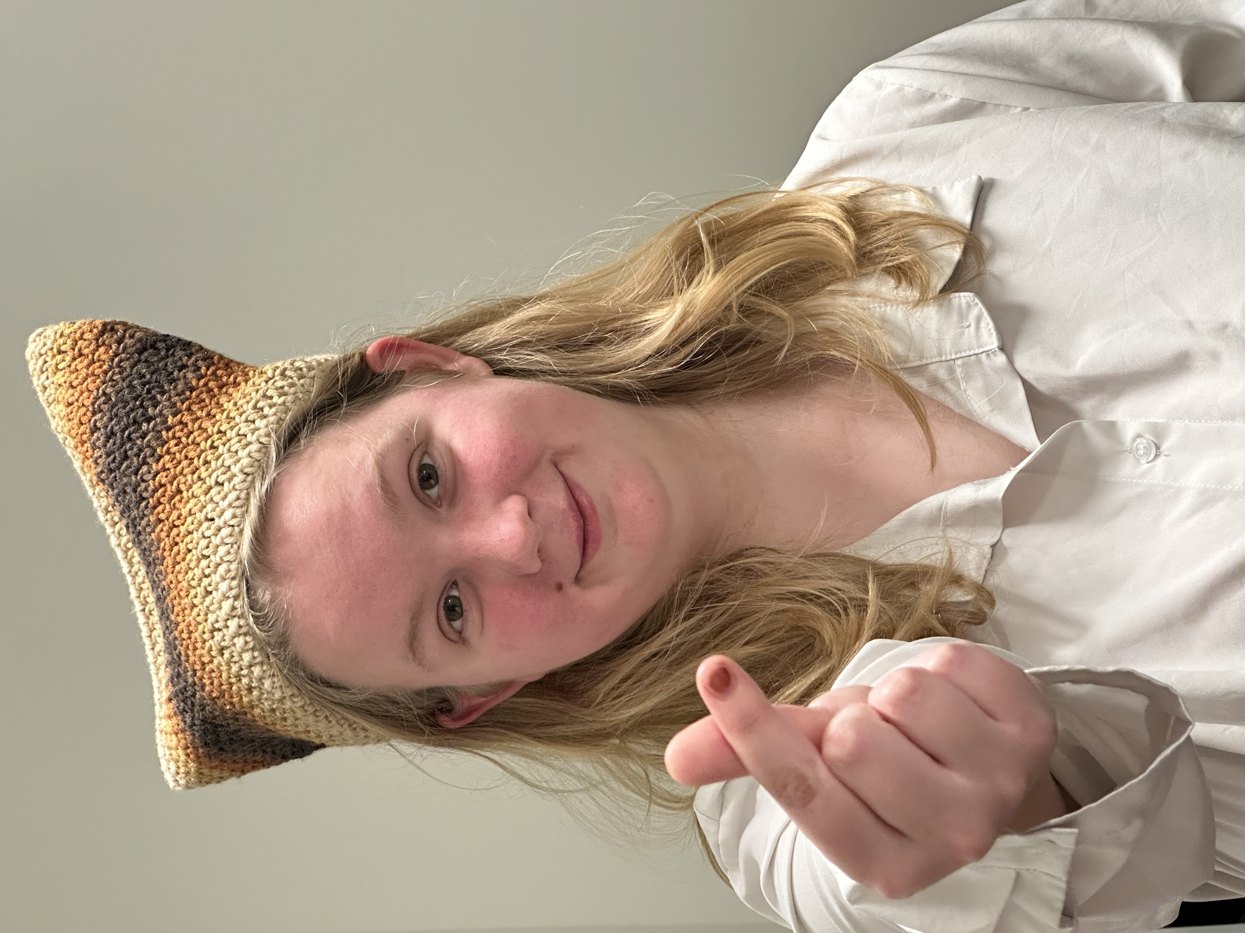Model wearing women's burgundy red crewneck artwork tee with small white triangle overlapping larger black triangle.